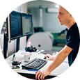 Young professional standing at computer in printing lab