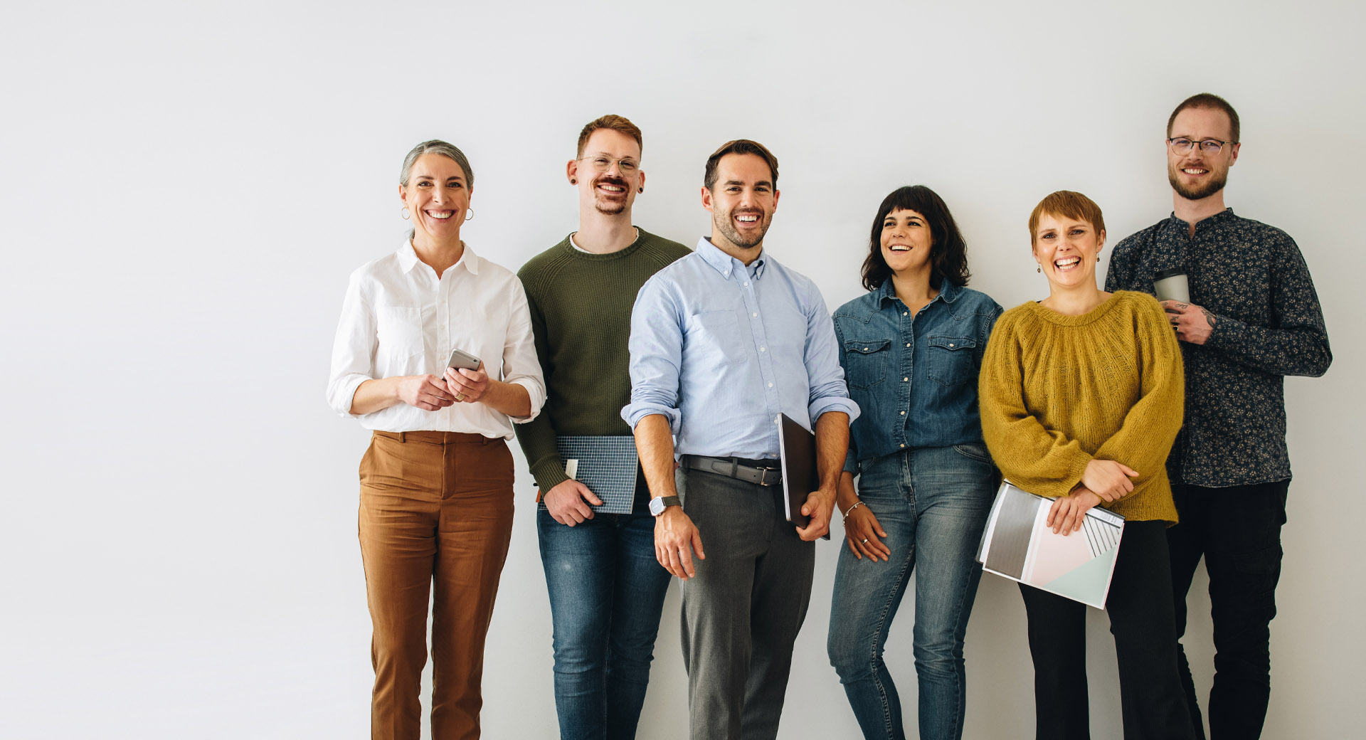 Six smiling people grouped together.