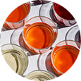 Small sampling cups filled with different colored beverages