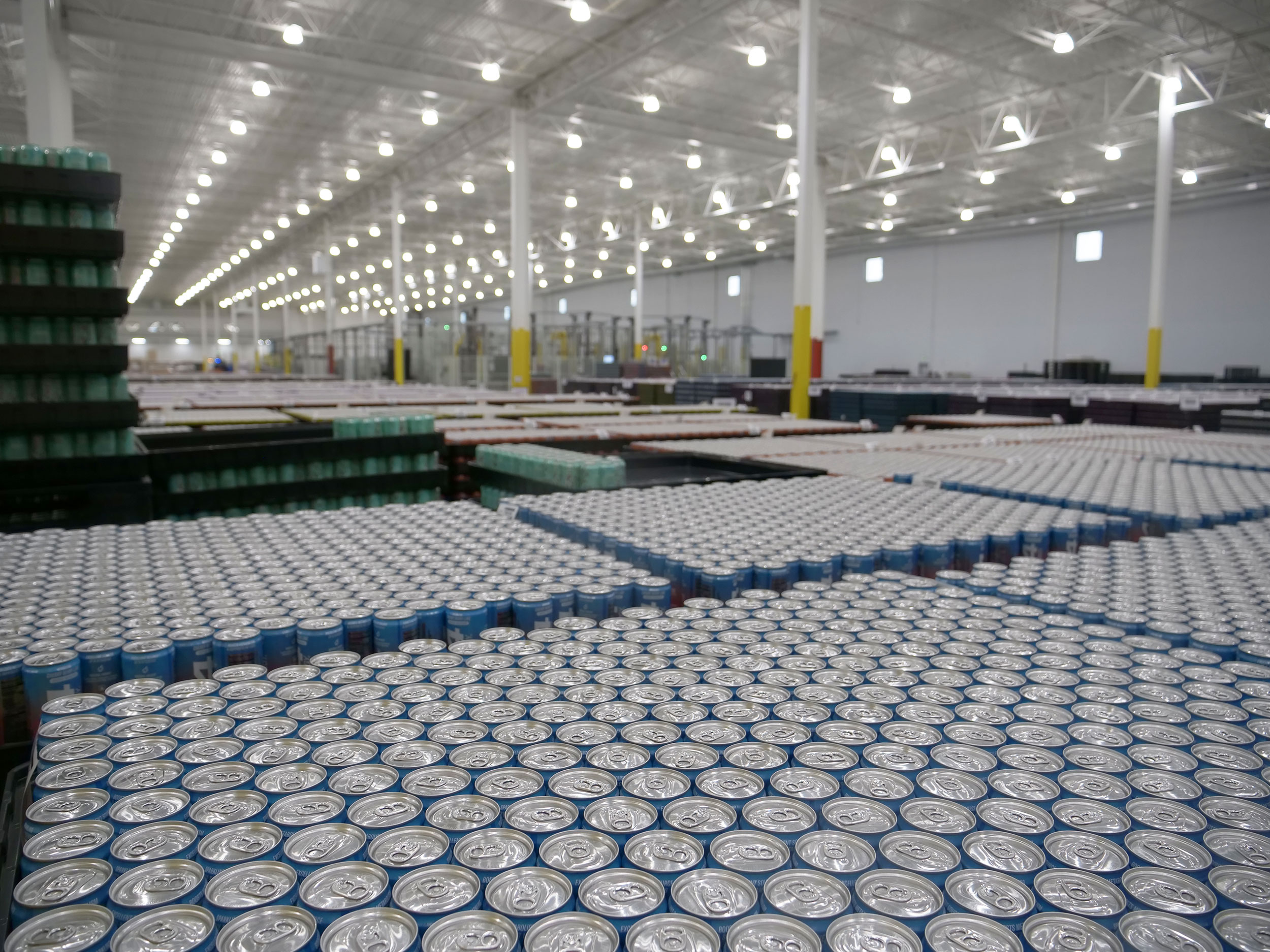 Hundreds of silver cans on can manufacturing line.