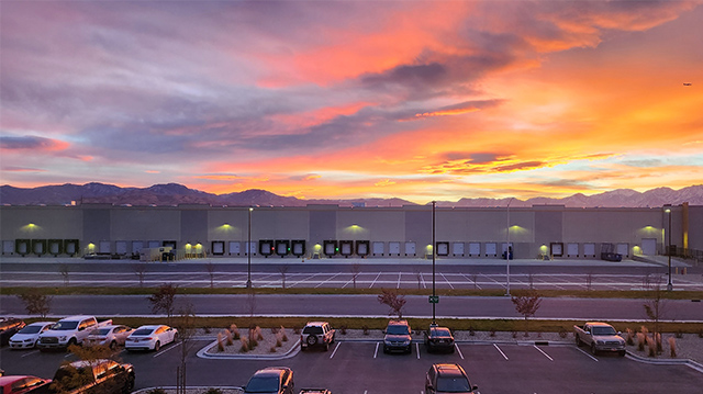 Picture of the Vobev facility and parking lot with the sun setting in the background.